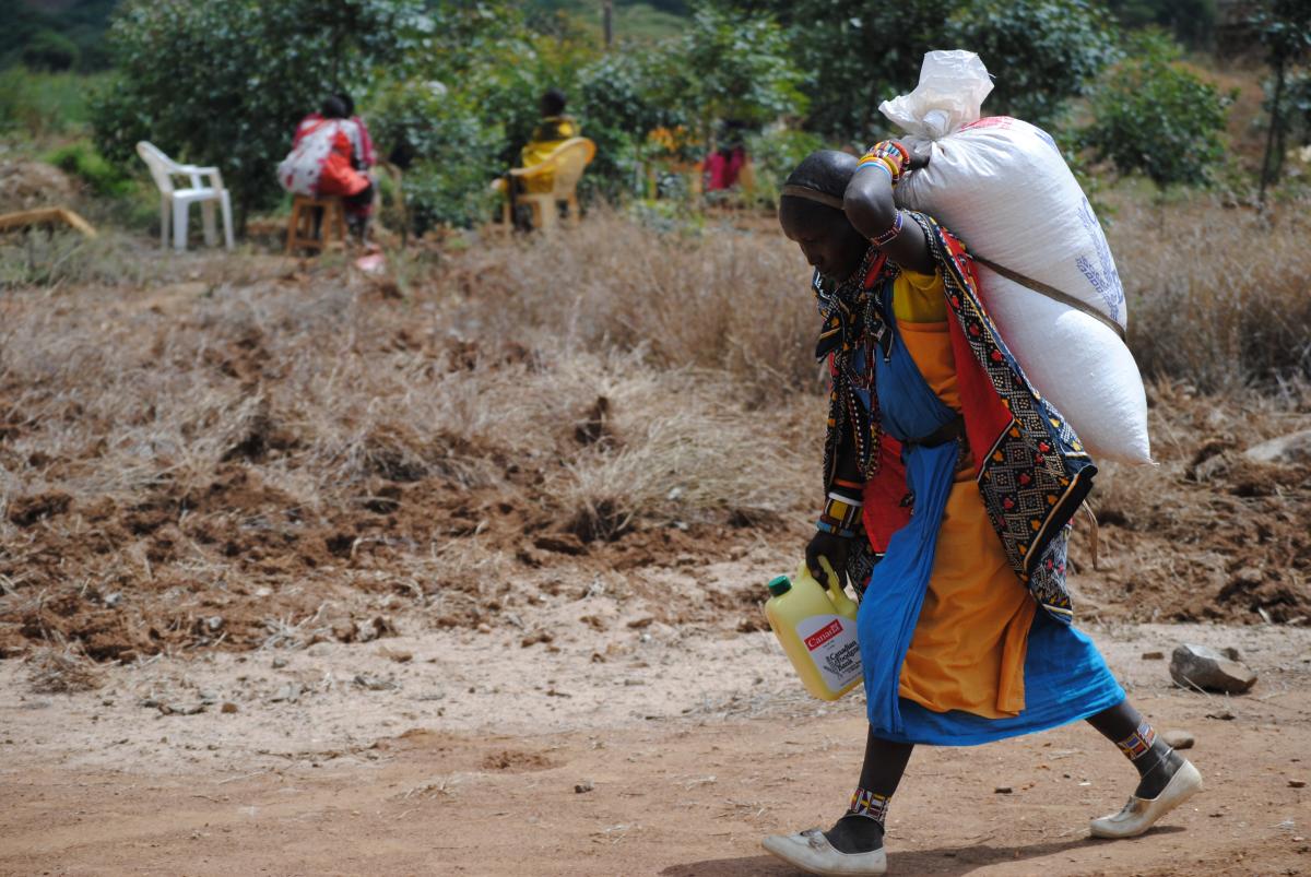 A woman carrying a Canadian Foodgrains Bank bag of grain