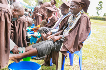 New graduate Edward Okiror has his feet washed by an instructor.