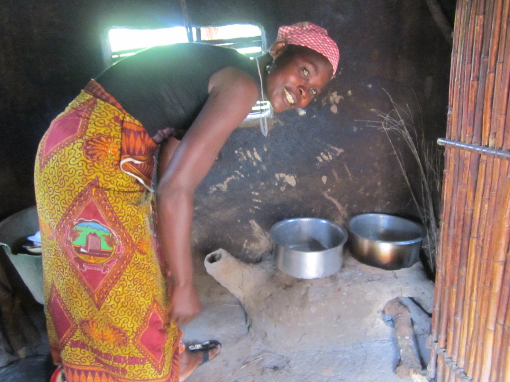 A woman shows her firewood energy saving stove at Michelenje community
