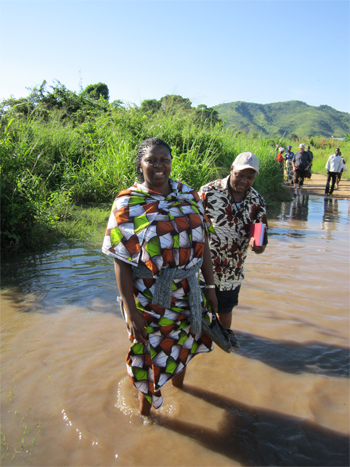 Esther & Istifanus as they cross a stream in Mesumba, Lunho, Mozambique
