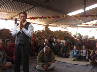 You can see in the background that the walls of this church where the community gathers were reduced to ½ the height by the earthquake and there is a new temporary roof.