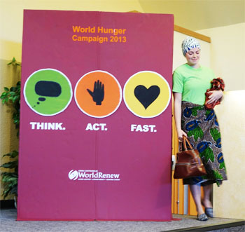 Catherine Sevenhuysen stands before a giant replica of World Renew’s World Hunger devotional booklet and performs a short skit that was part of Sunday worship during the church’s World Hunger campaign.