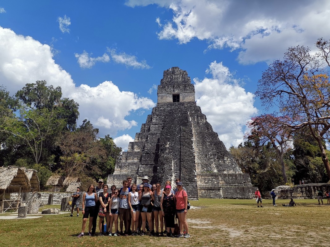 a group photo in front of an ancient Guatemalan temple