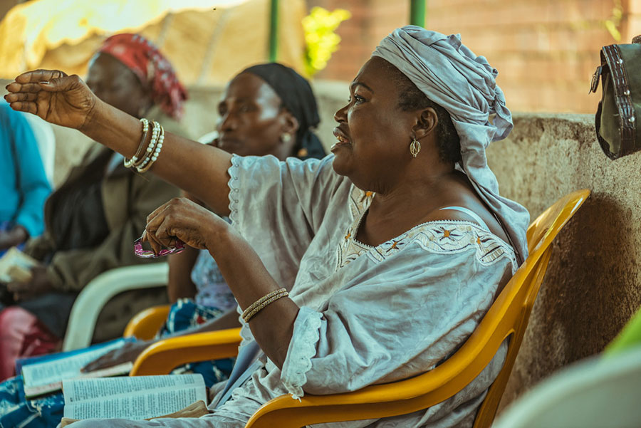 a woman gesturing while speaking during a bible study