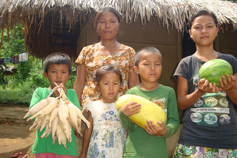 an Indian mother and her children posing with their crops
