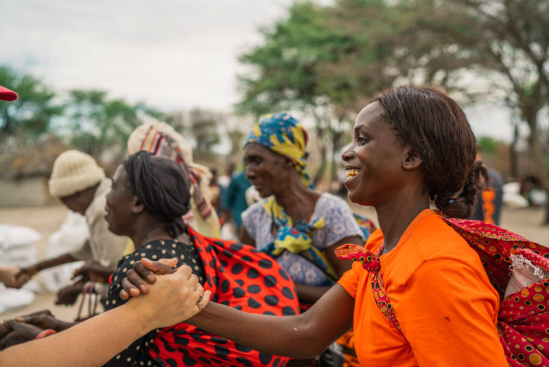 RS32860_Zambia PD IDR-Nov 2019-HIGHRES-223 (1) woman greeting friend with handshake and smile advocate for peace and justice work