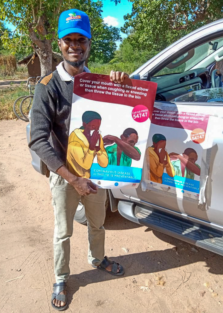 Man holding poster with covid prevention information