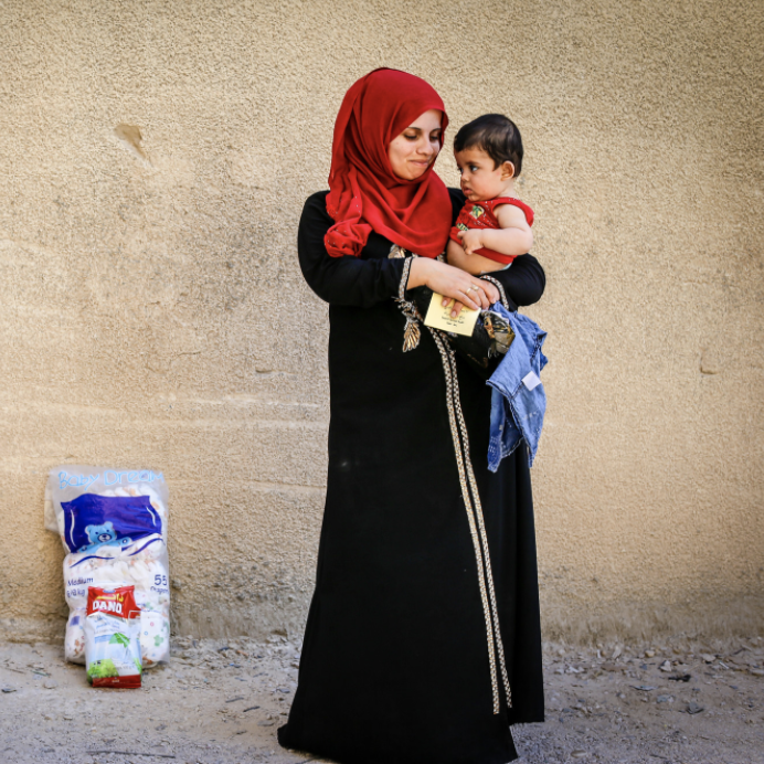 Screen Shot 2020-11-16 at 2.36.32 PM Woman with red headscarf holding a toddler