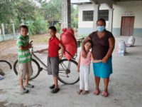 Honduran mother wearing a face mask and standing with her daughter and two sons