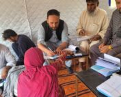 afghanistan people gathering around with financial papers
