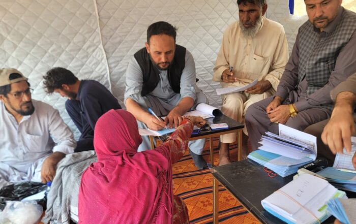 afghanistan people gathering around with financial papers