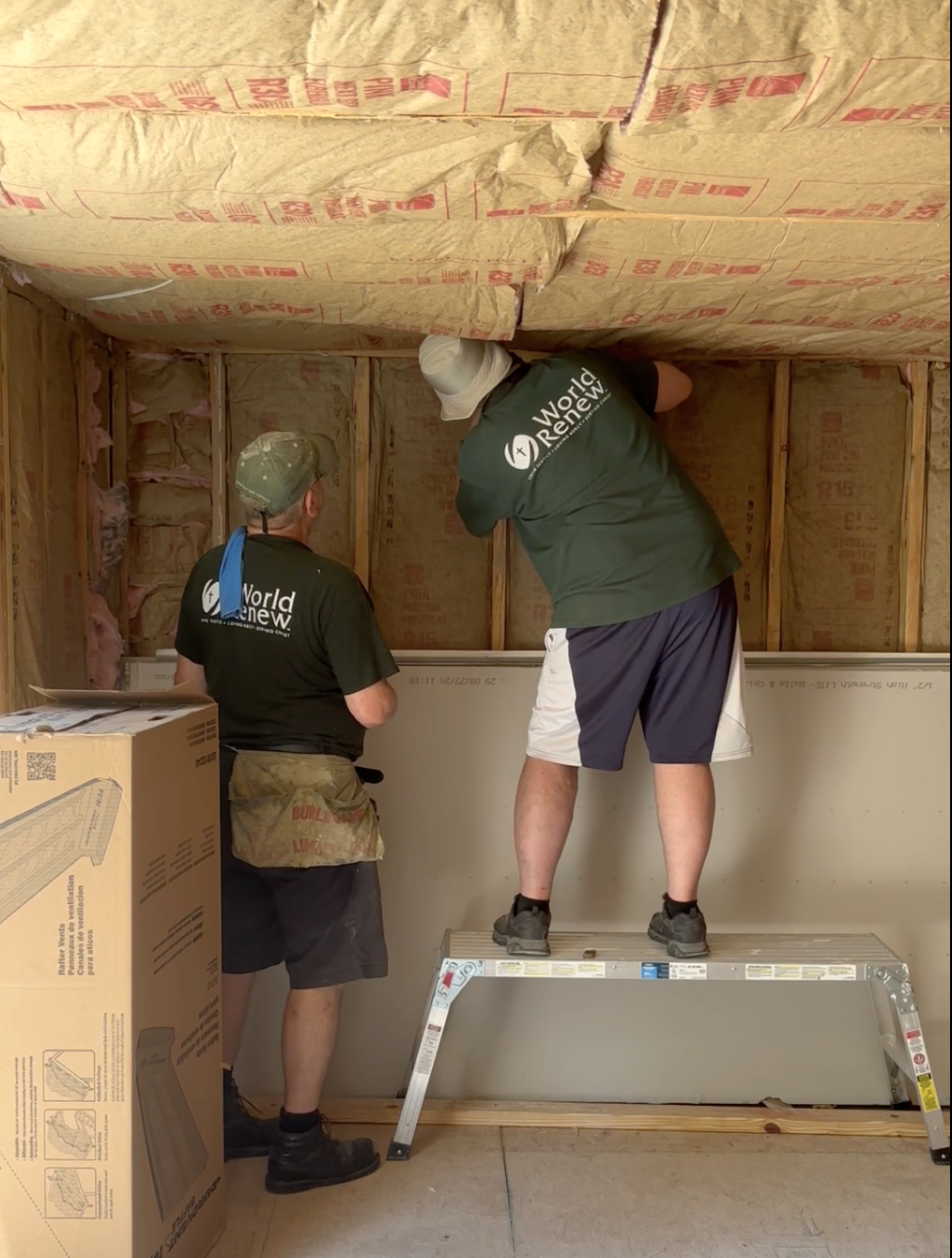 volunteers working on house ceiling insulation