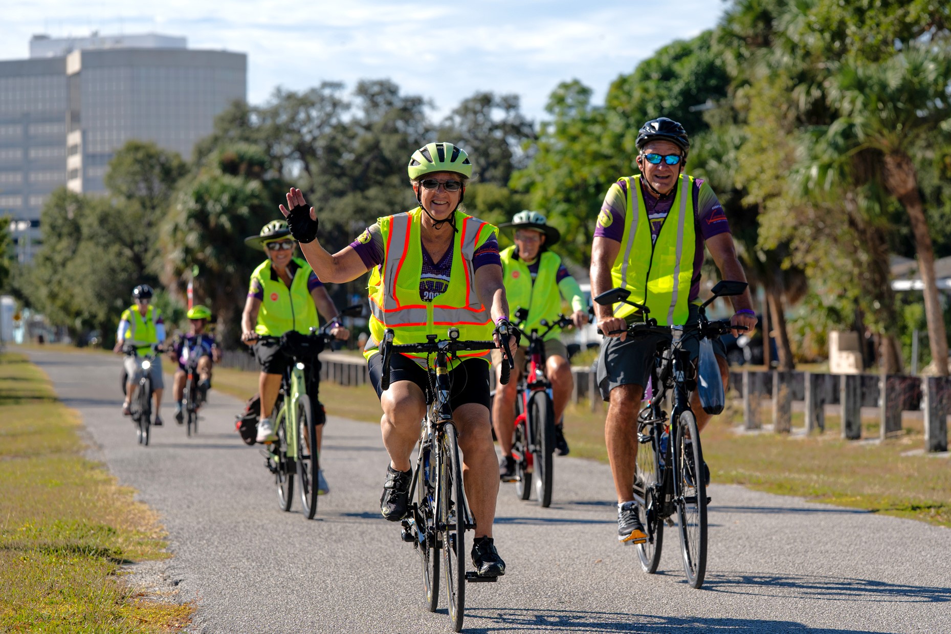 cyclists wearing reflective clothing and smiling at camera