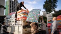 humanitarian workers unloading mattresses from truck