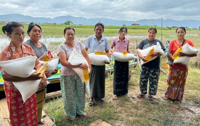 group of people lined up holding grain bags